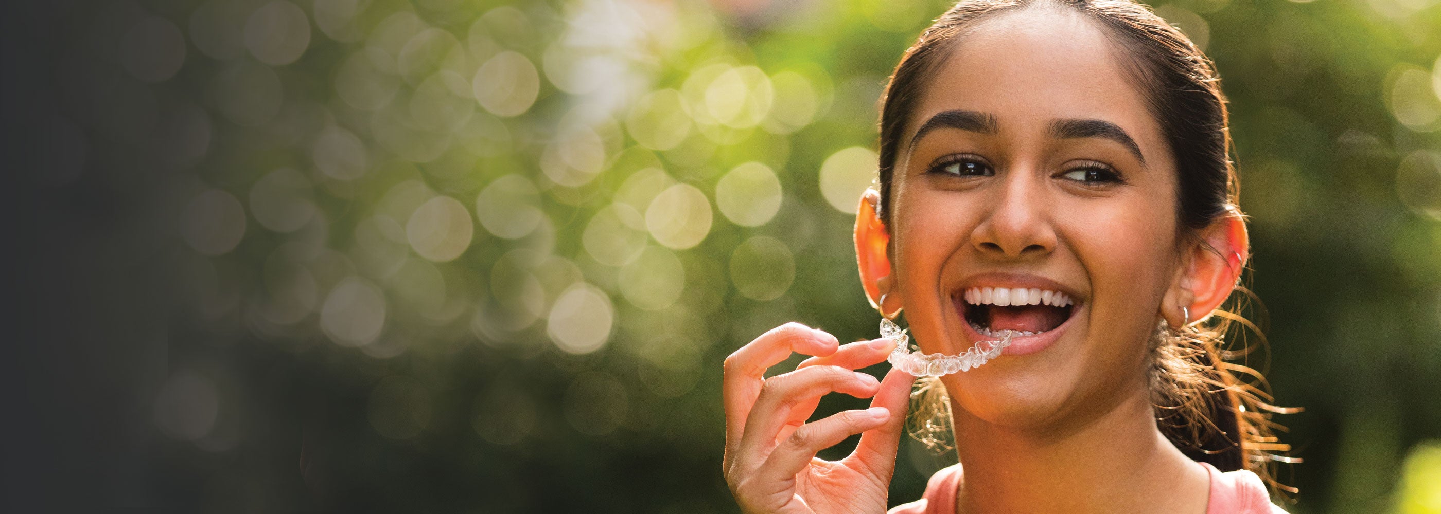 Teenager holding an Invisalign Teen aligner