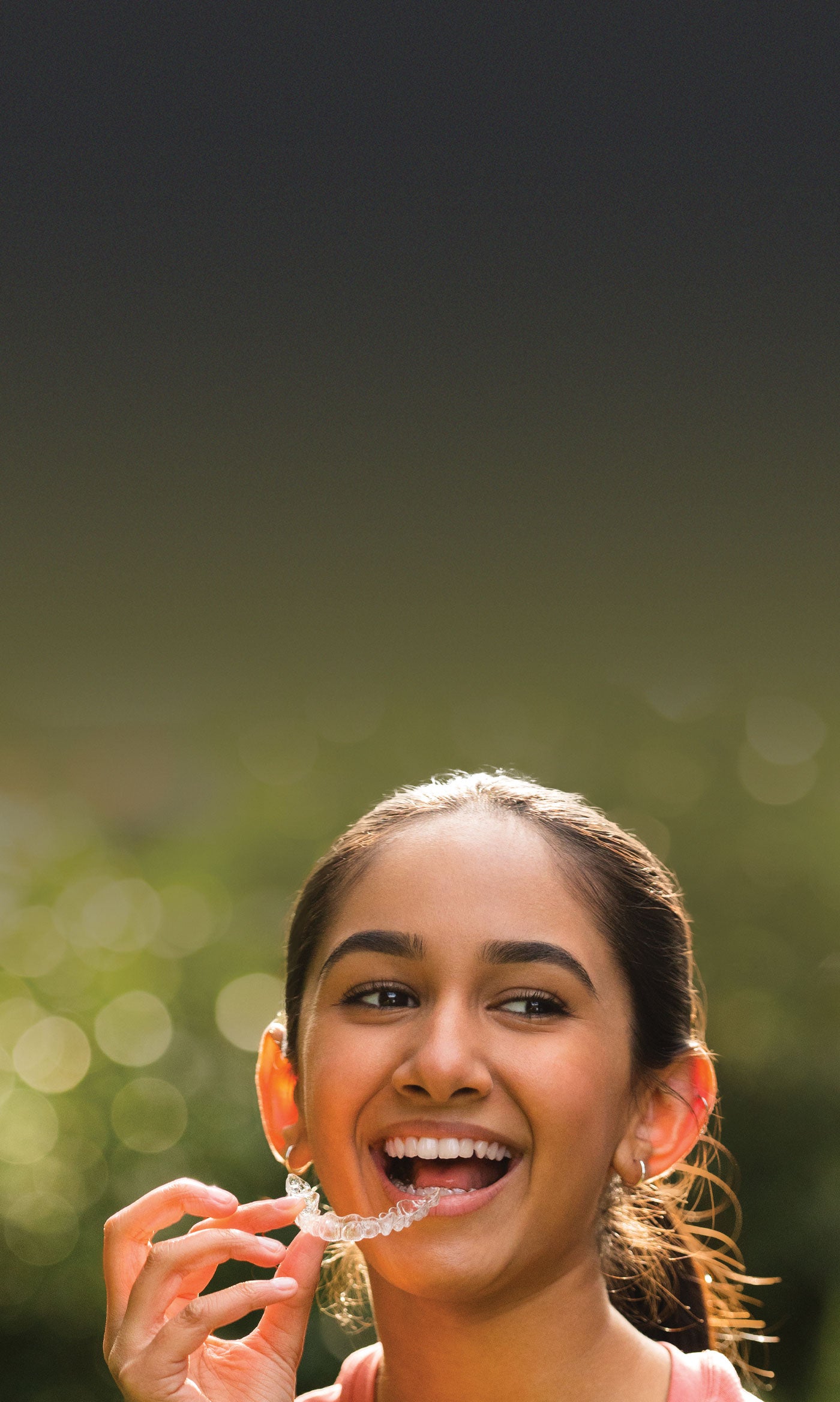 Teenager holding an Invisalign Teen aligner